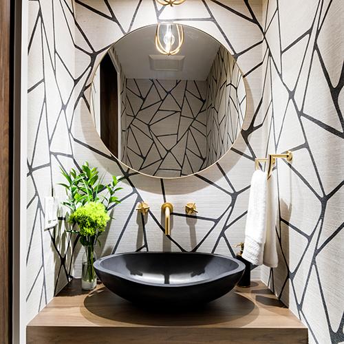 A bathroom with a geometric black lined pattern on a white wall