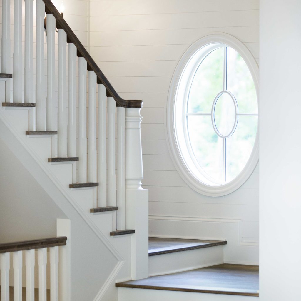 A circular window near a landing on a stairway