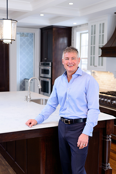 Todd standing proudly next to a countertop in a hand made home